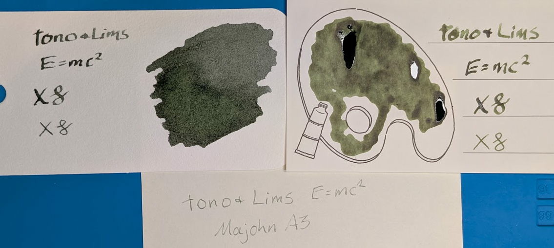 Photo of two swatch cards and a piece of paper, all with writing samples in the same ink, under natural light. Top left is a col-o-ring swatch card, top right is an Iroful swatch card, bottom center is a Midori note sheet. The col-o-ring swatch card has a large blob of dark gray ink with a green tint to it, and in writing with a stub nib is "Tono & Lims E=mc²" followed by "XX" and two curlicues in stub and fine nibs. The Iroful swatch card has a large blob of olive green ink inside an outline of a paint palette and in writing with a stub nib is "Tono & Lims E=mc²" followed by "XX" and two curlicues in stub and fine nibs. The Midori note pad has a writing sample in olive green ink reading "Tono & Lims E=mc² / Majohn A3"