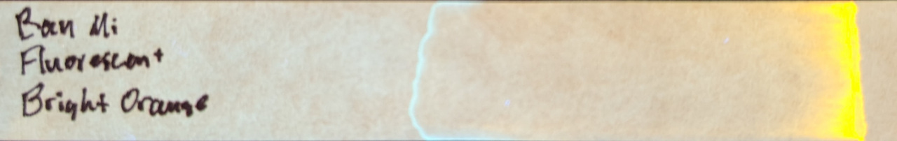 Photo of chromatography paper under UV light.