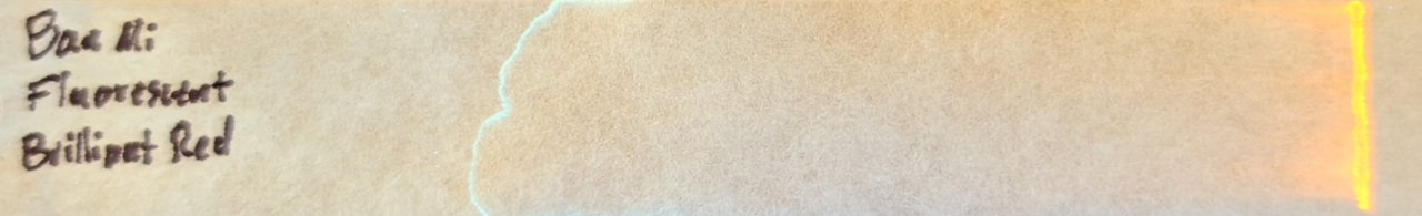 Photo of chromatography paper under UV light.
