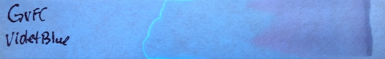 Photo of chromatography paper under UV light.